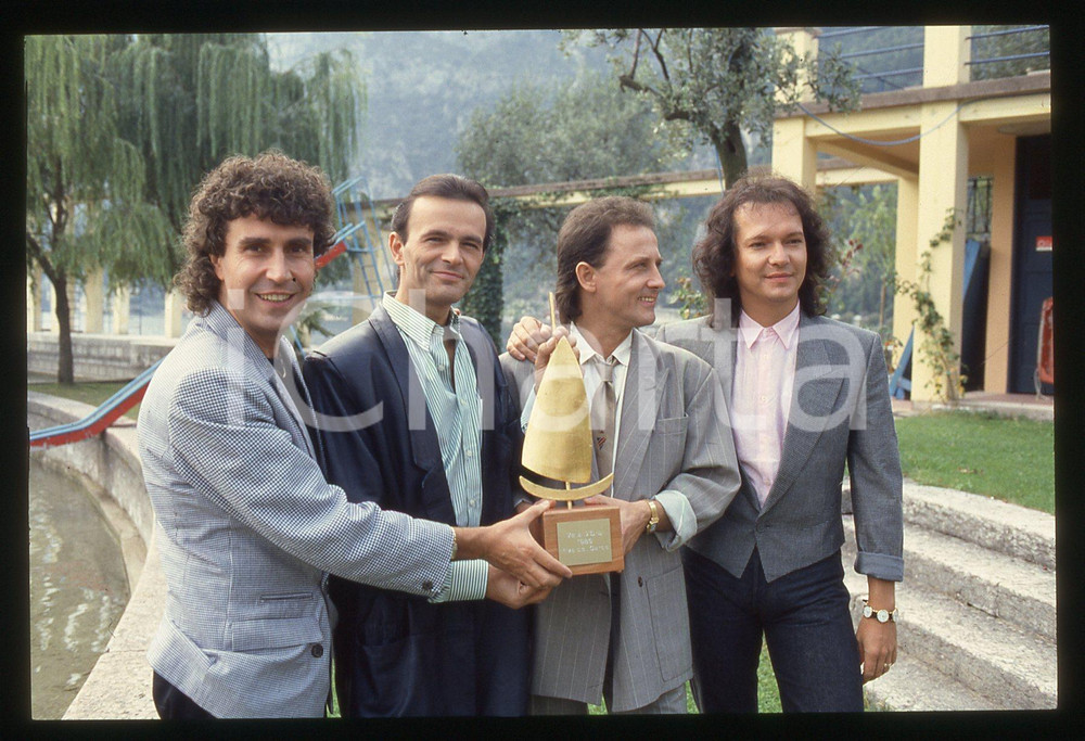 35mm vintage slide* 1988 RIVA DEL GARDA - POOH vincitori del premio VELA D'ORO *   Diapositiva d'epoca, in formato 35 mm.Nella diapositiva i componenti del gruppo musicale POOH: Roby Facchinetti, Dodi Battaglia, Stefano D'Orazio e Red Canzian. CONDIZIONI: GOODE' severamente vietata la riproduzione. Tutti i diritti sono riservati. ICharta mette in vendita, sul negozio eBay e in esclusiva sul sito "icharta" il proprio archivio composto da numerose diapositive e negativi fotografici d'epoca, tutti originali e autentici, che attraversano la storia del costume italiano tra gli la fine degli anni Sessanta e Novanta.Si tratta di uno sguardo inedito sull'attualit&agrave;, la politica, la vita quotidiana, il gossip e la cultura, che fotografa il cambiamento della nazione in quest'ultimo scorcio del XX secolo. Un'occasione unica per il mercato del collezionismo, che vede finalmente disponibile un archivio eccezionale per vastit&agrave;, tematiche e condizioni, in un settore (il negativo fotografico e la diapositiva) di assoluta novit&agrave; e dalle interessanti prospettive di investimento.  originale e autentica 1