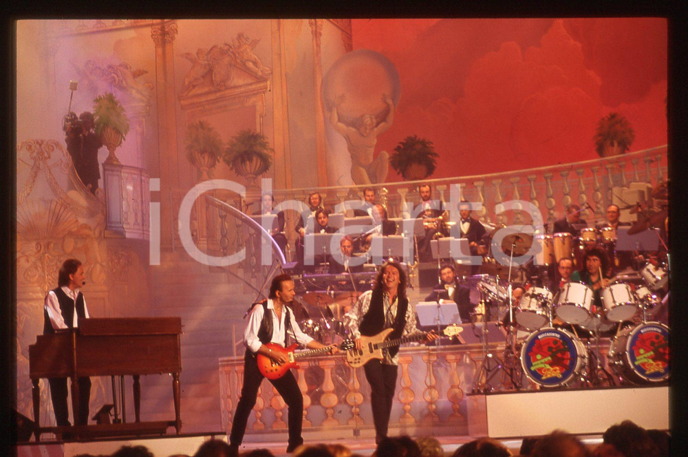 35mm vintage slide* 1990ca MUSICA - POOH durante una trasmissione televisiva   Diapositiva d'epoca, in formato 35 mm.Nella diapositiva Dodi Battaglia, Roby Facchinetti, Red Canzian e Stefano D'Orazio. CONDIZIONI: GOODE' severamente vietata la riproduzione. Tutti i diritti sono riservati. ICharta mette in vendita, sul negozio eBay e in esclusiva sul sito "icharta" il proprio archivio composto da numerose diapositive e negativi fotografici d'epoca, tutti originali e autentici, che attraversano la storia del costume italiano tra gli la fine degli anni Sessanta e Novanta.Si tratta di uno sguardo inedito sull'attualit&agrave;, la politica, la vita quotidiana, il gossip e la cultura, che fotografa il cambiamento della nazione in quest'ultimo scorcio del XX secolo. Un'occasione unica per il mercato del collezionismo, che vede finalmente disponibile un archivio eccezionale per vastit&agrave;, tematiche e condizioni, in un settore (il negativo fotografico e la diapositiva) di assoluta novit&agrave; e dalle interessanti prospettive di investimento.  originale e autentica 1