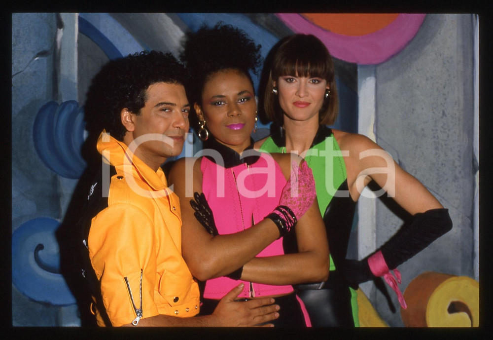 35mm vintage slide* 1985ca PASSENGERS - Gruppo musicale ITALO DISCO (13)  Nella diapositiva compaiono Gesualdo "Kim" Arena - Elwanda Contreras - Mary Shay Collen  Diapositiva d'epoca, in formato 35 mm. CONDIZIONI: GOOD ICharta mette in vendita, sul negozio eBay e in esclusiva sul sito "icharta" il proprio archivio composto da numerose diapositive e negativi fotografici d'epoca, tutti originali e autentici, che attraversano la storia del costume italiano tra gli la fine degli anni Sessanta e Novanta.Si tratta di uno sguardo inedito sull'attualit&agrave;, la politica, la vita quotidiana, il gossip e la cultura, che fotografa il cambiamento della nazione in quest'ultimo scorcio del XX secolo. Un'occasione unica per il mercato del collezionismo, che vede finalmente disponibile un archivio eccezionale per vastit&agrave;, tematiche e condizioni, in un settore (il negativo fotografico e la diapositiva) di assoluta novit&agrave; e dalle interessanti prospettive di investimento.  originale e autentica 1