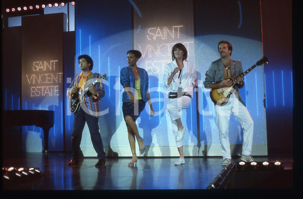 35mm vintage slide* 1984 SAINT VINCENT -  UN DISCO PER L'ESTATE -   PASSENGERS  Nella diapositiva compaiono Gesualdo "Kim" Arena - Elwanda Contreras - Mary Shay Collen - Chuck Rolando Diapositiva d'epoca, in formato 35 mm. CONDIZIONI: GOOD ICharta mette in vendita, sul negozio eBay e in esclusiva sul sito "icharta" il proprio archivio composto da numerose diapositive e negativi fotografici d'epoca, tutti originali e autentici, che attraversano la storia del costume italiano tra gli la fine degli anni Sessanta e Novanta.Si tratta di uno sguardo inedito sull'attualit&agrave;, la politica, la vita quotidiana, il gossip e la cultura, che fotografa il cambiamento della nazione in quest'ultimo scorcio del XX secolo. Un'occasione unica per il mercato del collezionismo, che vede finalmente disponibile un archivio eccezionale per vastit&agrave;, tematiche e condizioni, in un settore (il negativo fotografico e la diapositiva) di assoluta novit&agrave; e dalle interessanti prospettive di investimento.  originale e autentica 1