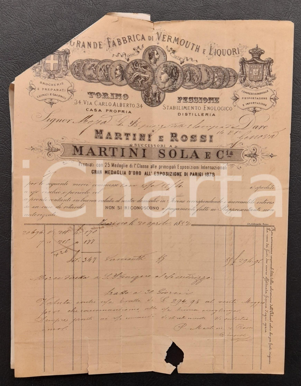 1882 TORINO Via Carlo Alberto 34 Grande Fabbrica di Vermouth e Liquori - Fattura Fattura commerciale d'epoca manoscritta, su carta intestata illustrata. Unita cambiale pubblicitaria.Presente marca da bollo al verso.PAGINE: 1 VERY POOR/gravemente danneggiato piegature d'epoca; strappi marginali; mancanza al lato inferiore; residuo cartaceo al verso Formato: 22x28 cm originale e autentica 1