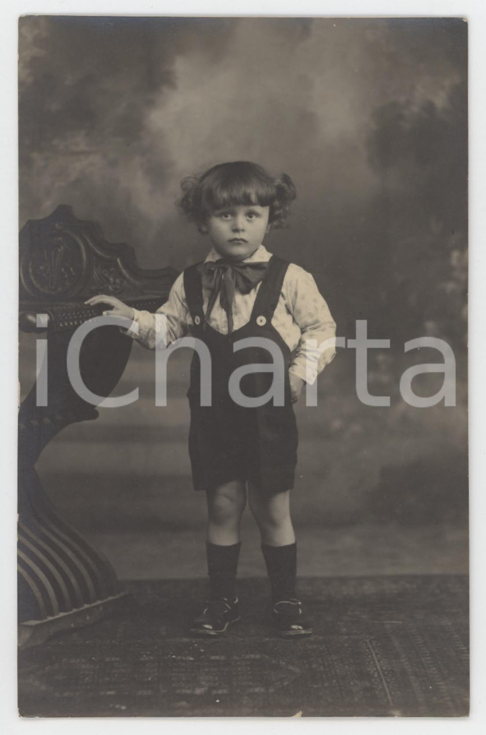 1920 ca COSTUME ITALIA Bambina con fiocco e salopette - Foto anonima 9x14 cm  Fotografia originale d'epoca, in formato cartolina postale. GOOD/buono minima sbrecciatura al lato inferiore Formato: 9x14 cm originale e autentica 1