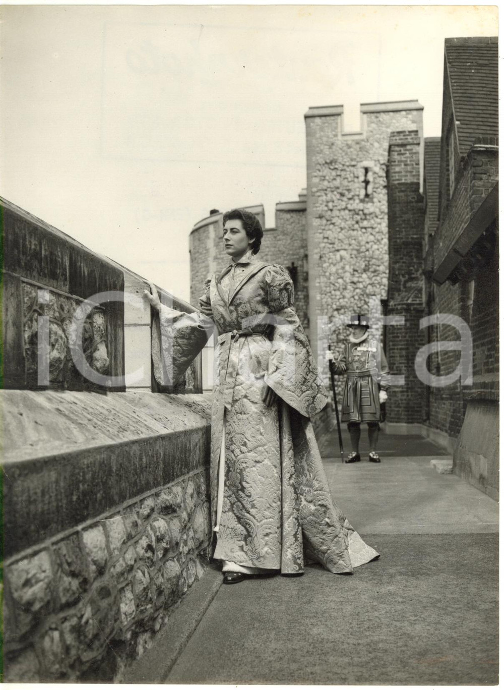1953 TOWER OF LONDON Pauline FORRESTER with housecoat from the movie YOUNG BESS  Fotografia d'epoca con didascalia coeva al verso.  CONDIZIONI: FAIR (piegatura dell'angolo inferiore sinistro; sovraimpressione della didascalia; lievi macchie e difetti di stampa) FORMATO: 15x20 cm     originale e autentica 1