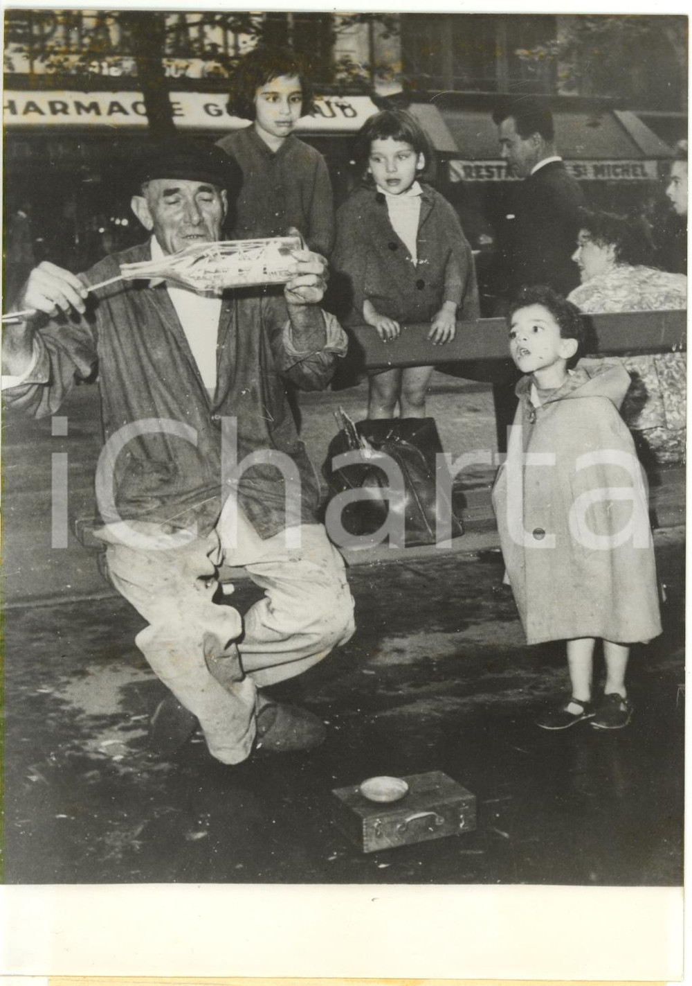 1960 PARIGI - Bambini osservano marinaio che costruisce nave in una bottiglia  Fotografia d'epoca con didascalia coeva.   CONDIZIONI: FAIR (lieve ondulatura al margine inferiore; vari aloni e difetti di stampa) 13x18 cm     originale e autentica 1