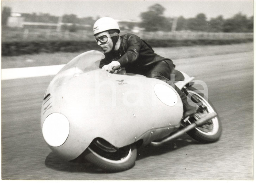 1956 MONZA GP DELLE NAZIONI - Ken KAVANAGH su MOTO GUZZI 350 durante le prove  Fotografia d'epoca con didascalia al verso.  CONDIZIONI: G (leggera sovraimpressione della didascalia) FORMATO: 18x13 cm     originale e autentica 1