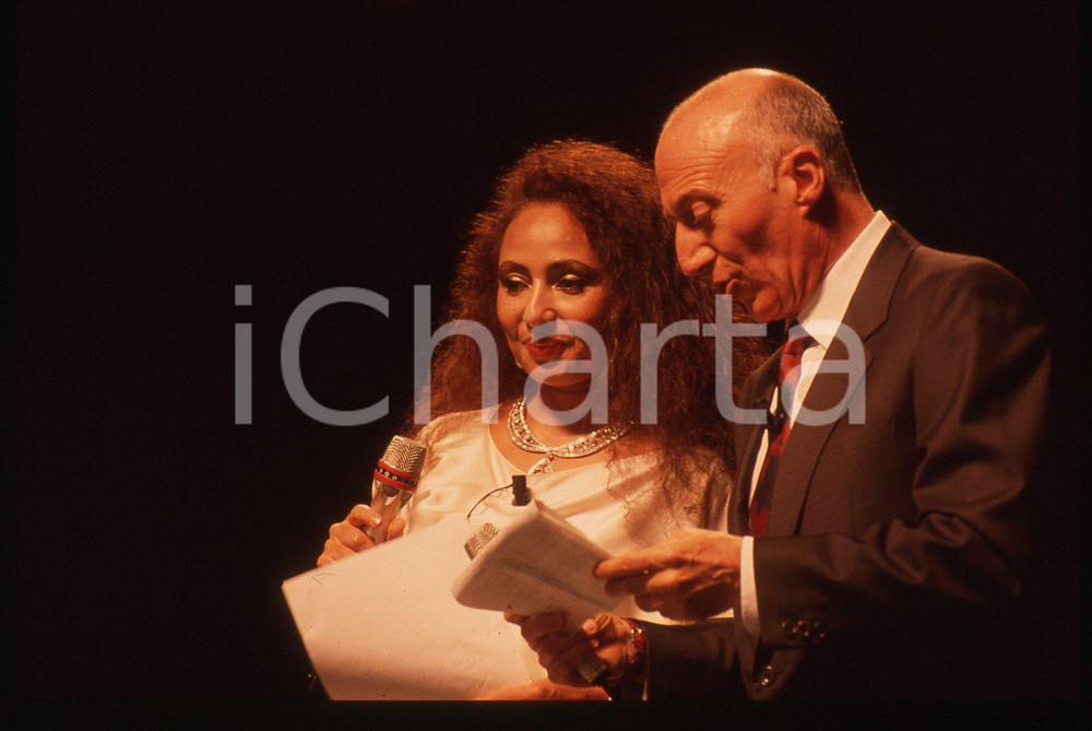 35mm vintage slide* 1990 MILANO Gianfranco DE LAURENTIIS al Galà  ITALIA '90  (1 La manifestazione si &egrave; tenuta presso il Palatrussardi.Nella diapositiva &egrave; inoltre presente Lara Saint PaulDiapositiva d'epoca, in formato 35 mm. CONDIZIONI: GOODE' severamente vietata la riproduzione. Tutti i diritti sono riservati. ICharta mette in vendita, sul negozio eBay e in esclusiva sul sito "icharta" il proprio archivio composto da numerose diapositive e negativi fotografici d'epoca, tutti originali e autentici, che attraversano la storia del costume italiano tra gli la fine degli anni Sessanta e Novanta.Si tratta di uno sguardo inedito sull'attualit&agrave;, la politica, la vita quotidiana, il gossip e la cultura, che fotografa il cambiamento della nazione in quest'ultimo scorcio del XX secolo. Un'occasione unica per il mercato del collezionismo, che vede finalmente disponibile un archivio eccezionale per vastit&agrave;, tematiche e condizioni, in un settore (il negativo fotografico e la diapositiva) di assoluta novit&agrave; e dalle interessanti prospettive di investimento.  originale e autentica 1