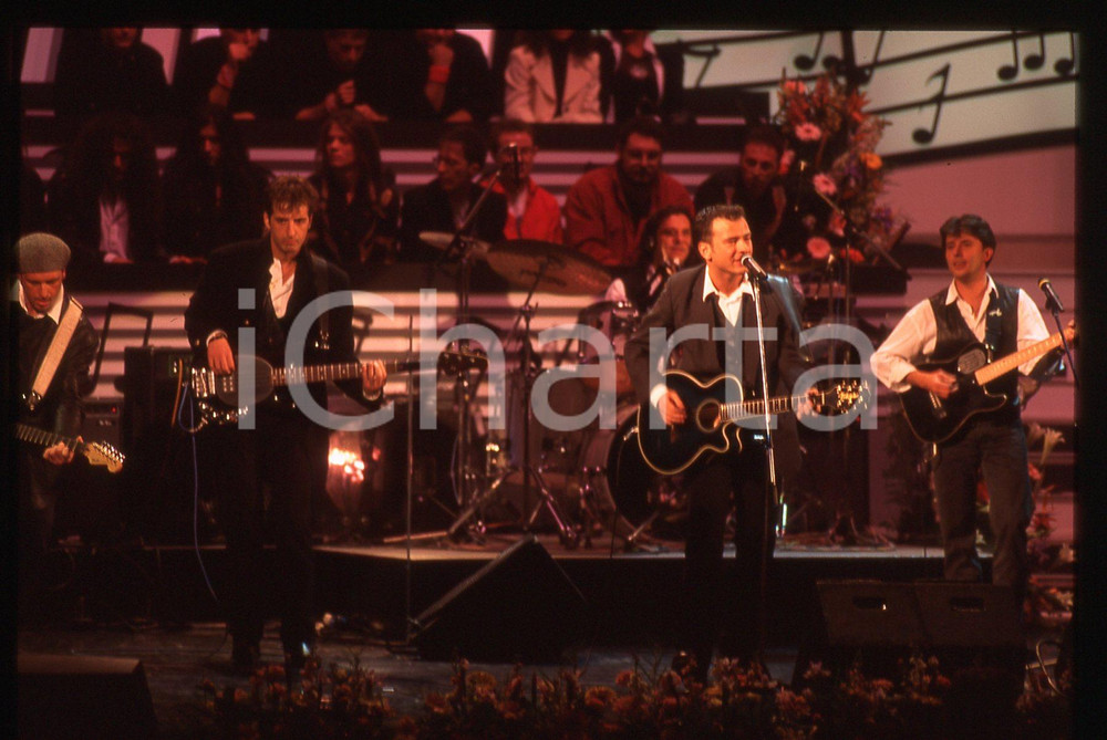 35mm vintage slide* 1994 SANREMO GIOVANI Marco BRUNI Giorgio TERZI dei DECO 4  La diapositiva &egrave; stata scattata al Teatro Ariston. Non &egrave; chiaro il nome dei restanti componenti della bandDiapositiva d'epoca, in formato 35 mm. CONDIZIONI: GOODE' severamente vietata la riproduzione. Tutti i diritti sono riservati. ICharta mette in vendita, sul negozio eBay e in esclusiva sul sito "icharta" il proprio archivio composto da numerose diapositive e negativi fotografici d'epoca, tutti originali e autentici, che attraversano la storia del costume italiano tra gli la fine degli anni Sessanta e Novanta.Si tratta di uno sguardo inedito sull'attualit&agrave;, la politica, la vita quotidiana, il gossip e la cultura, che fotografa il cambiamento della nazione in quest'ultimo scorcio del XX secolo. Un'occasione unica per il mercato del collezionismo, che vede finalmente disponibile un archivio eccezionale per vastit&agrave;, tematiche e condizioni, in un settore (il negativo fotografico e la diapositiva) di assoluta novit&agrave; e dalle interessanti prospettive di investimento.  originale e autentica 1