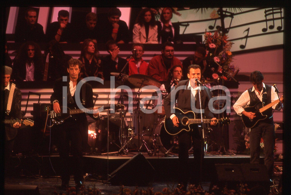 35mm vintage slide* 1994 SANREMO GIOVANI Marco BRUNI Giorgio TERZI dei DECO 5  La diapositiva &egrave; stata scattata al Teatro Ariston. Non &egrave; chiaro il nome dei restanti componenti della bandDiapositiva d'epoca, in formato 35 mm. CONDIZIONI: GOODE' severamente vietata la riproduzione. Tutti i diritti sono riservati. ICharta mette in vendita, sul negozio eBay e in esclusiva sul sito "icharta" il proprio archivio composto da numerose diapositive e negativi fotografici d'epoca, tutti originali e autentici, che attraversano la storia del costume italiano tra gli la fine degli anni Sessanta e Novanta.Si tratta di uno sguardo inedito sull'attualit&agrave;, la politica, la vita quotidiana, il gossip e la cultura, che fotografa il cambiamento della nazione in quest'ultimo scorcio del XX secolo. Un'occasione unica per il mercato del collezionismo, che vede finalmente disponibile un archivio eccezionale per vastit&agrave;, tematiche e condizioni, in un settore (il negativo fotografico e la diapositiva) di assoluta novit&agrave; e dalle interessanti prospettive di investimento.  originale e autentica 1