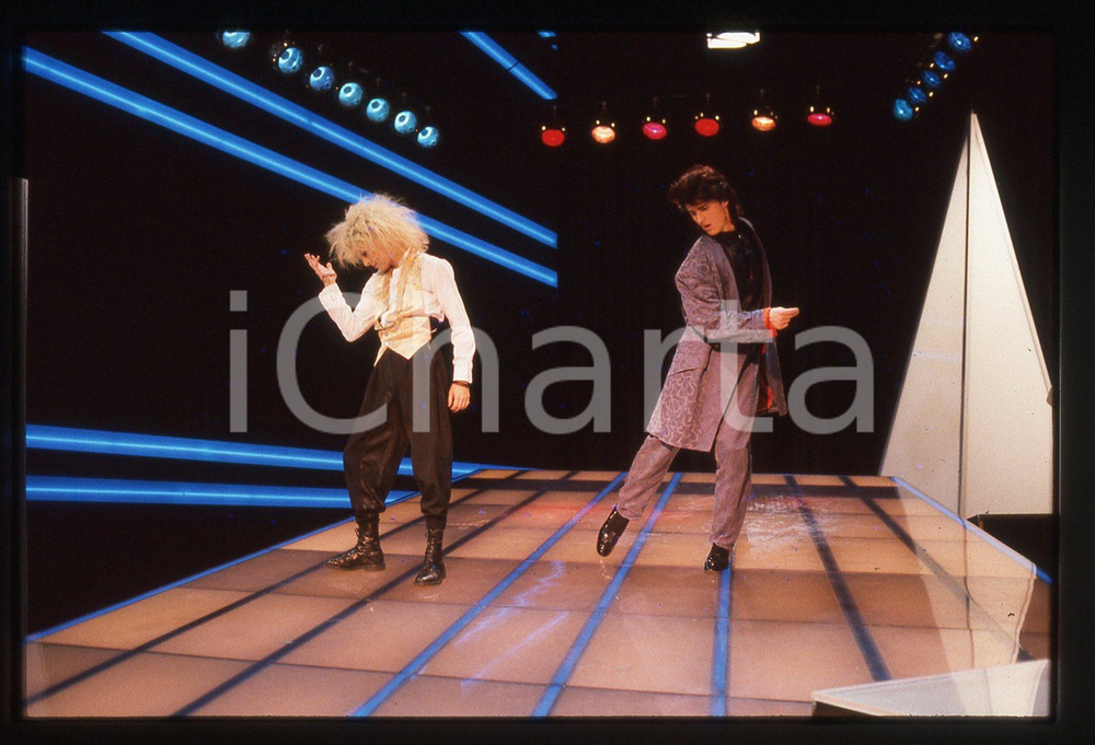 35mm vintage slide* 1985 FESTIVALBAR Markus MORL Mark JEFFERIS dei T.X.T. (12) Diapositiva d'epoca, in formato 35 mm. CONDIZIONI: GOODE' severamente vietata la riproduzione. Tutti i diritti sono riservati. ICharta mette in vendita, sul negozio eBay e in esclusiva sul sito "icharta" il proprio archivio composto da numerose diapositive e negativi fotografici d'epoca, tutti originali e autentici, che attraversano la storia del costume italiano tra gli la fine degli anni Sessanta e Novanta.Si tratta di uno sguardo inedito sull'attualit&agrave;, la politica, la vita quotidiana, il gossip e la cultura, che fotografa il cambiamento della nazione in quest'ultimo scorcio del XX secolo. Un'occasione unica per il mercato del collezionismo, che vede finalmente disponibile un archivio eccezionale per vastit&agrave;, tematiche e condizioni, in un settore (il negativo fotografico e la diapositiva) di assoluta novit&agrave; e dalle interessanti prospettive di investimento.  originale e autentica 1