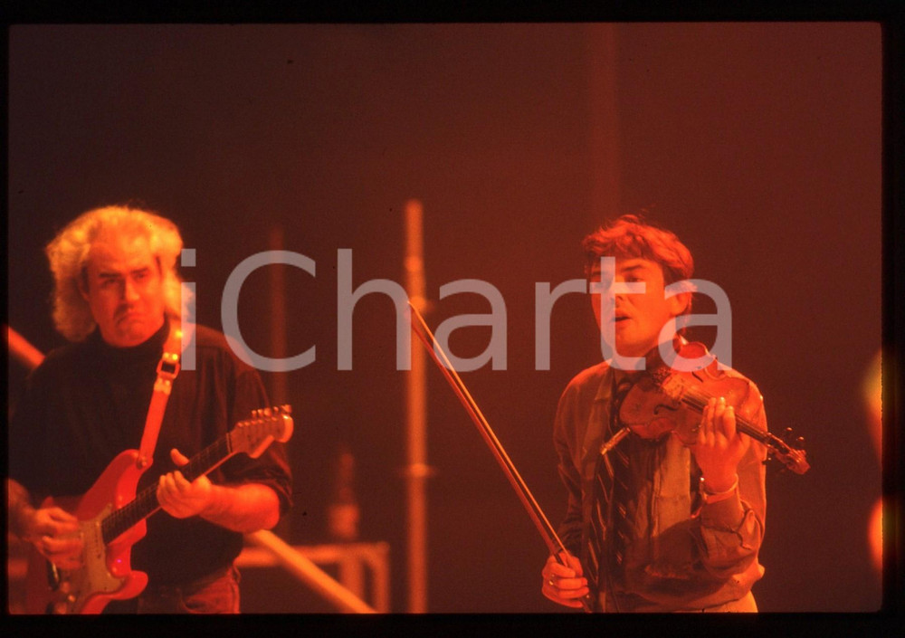 35mm vintage slide* 1985ca MUSICA - PFM Franco MUSSIDA Mauro PAGANI Concerto 5 Diapositiva d'epoca, in formato 35 mm. CONDIZIONI: GOODE' severamente vietata la riproduzione. Tutti i diritti sono riservati. ICharta mette in vendita, sul negozio eBay e in esclusiva sul sito "icharta" il proprio archivio composto da numerose diapositive e negativi fotografici d'epoca, tutti originali e autentici, che attraversano la storia del costume italiano tra gli la fine degli anni Sessanta e Novanta.Si tratta di uno sguardo inedito sull'attualit&agrave;, la politica, la vita quotidiana, il gossip e la cultura, che fotografa il cambiamento della nazione in quest'ultimo scorcio del XX secolo. Un'occasione unica per il mercato del collezionismo, che vede finalmente disponibile un archivio eccezionale per vastit&agrave;, tematiche e condizioni, in un settore (il negativo fotografico e la diapositiva) di assoluta novit&agrave; e dalle interessanti prospettive di investimento.  originale e autentica 1