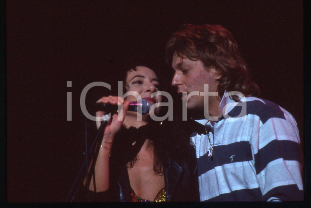 35mm vintage slide* 1985ca ITALIA MUSICA Giulia FASOLINO Alessandro BONO Live 1 Diapositiva d'epoca, in formato 35 mm. CONDIZIONI: GOODE' severamente vietata la riproduzione. Tutti i diritti sono riservati. ICharta mette in vendita, sul negozio eBay e in esclusiva sul sito "icharta" il proprio archivio composto da numerose diapositive e negativi fotografici d'epoca, tutti originali e autentici, che attraversano la storia del costume italiano tra gli la fine degli anni Sessanta e Novanta.Si tratta di uno sguardo inedito sull'attualit&agrave;, la politica, la vita quotidiana, il gossip e la cultura, che fotografa il cambiamento della nazione in quest'ultimo scorcio del XX secolo. Un'occasione unica per il mercato del collezionismo, che vede finalmente disponibile un archivio eccezionale per vastit&agrave;, tematiche e condizioni, in un settore (il negativo fotografico e la diapositiva) di assoluta novit&agrave; e dalle interessanti prospettive di investimento.  originale e autentica 1