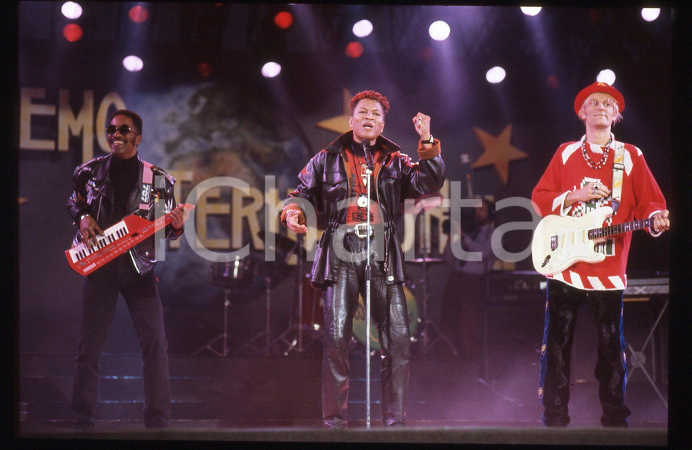 35mm vintage slide* 1991 SANREMO INTERNATIONAL George CHANDLER  LONDONBEAT 35 Nella diapositiva compaiono anche Jimmy Helms e William HenshallDiapositiva d'epoca, in formato 35 mm. CONDIZIONI: GOODE' severamente vietata la riproduzione. Tutti i diritti sono riservati. ICharta mette in vendita, sul negozio eBay e in esclusiva sul sito "icharta" il proprio archivio composto da numerose diapositive e negativi fotografici d'epoca, tutti originali e autentici, che attraversano la storia del costume italiano tra gli la fine degli anni Sessanta e Novanta.Si tratta di uno sguardo inedito sull'attualit&agrave;, la politica, la vita quotidiana, il gossip e la cultura, che fotografa il cambiamento della nazione in quest'ultimo scorcio del XX secolo. Un'occasione unica per il mercato del collezionismo, che vede finalmente disponibile un archivio eccezionale per vastit&agrave;, tematiche e condizioni, in un settore (il negativo fotografico e la diapositiva) di assoluta novit&agrave; e dalle interessanti prospettive di investimento.  originale e autentica 1