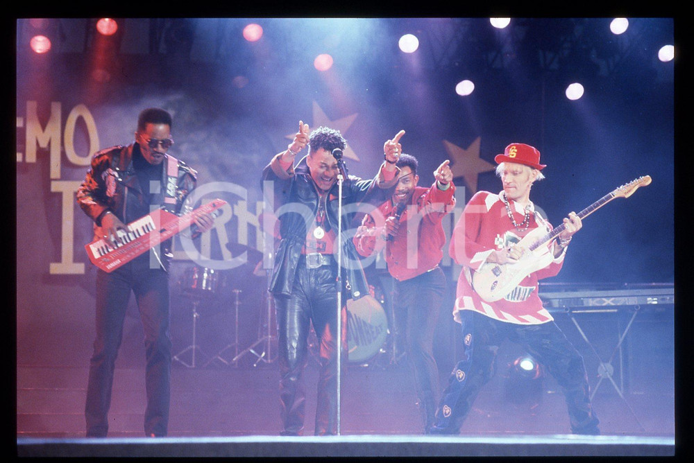 35mm vintage slide* 1991 SANREMO INTERNATIONAL George CHANDLER  LONDONBEAT 36 Nella diapositiva compaiono anche Jimmy Helms, William Henshall e Jimmy ChambersDiapositiva d'epoca, in formato 35 mm. CONDIZIONI: GOODE' severamente vietata la riproduzione. Tutti i diritti sono riservati. ICharta mette in vendita, sul negozio eBay e in esclusiva sul sito "icharta" il proprio archivio composto da numerose diapositive e negativi fotografici d'epoca, tutti originali e autentici, che attraversano la storia del costume italiano tra gli la fine degli anni Sessanta e Novanta.Si tratta di uno sguardo inedito sull'attualit&agrave;, la politica, la vita quotidiana, il gossip e la cultura, che fotografa il cambiamento della nazione in quest'ultimo scorcio del XX secolo. Un'occasione unica per il mercato del collezionismo, che vede finalmente disponibile un archivio eccezionale per vastit&agrave;, tematiche e condizioni, in un settore (il negativo fotografico e la diapositiva) di assoluta novit&agrave; e dalle interessanti prospettive di investimento.  originale e autentica 1