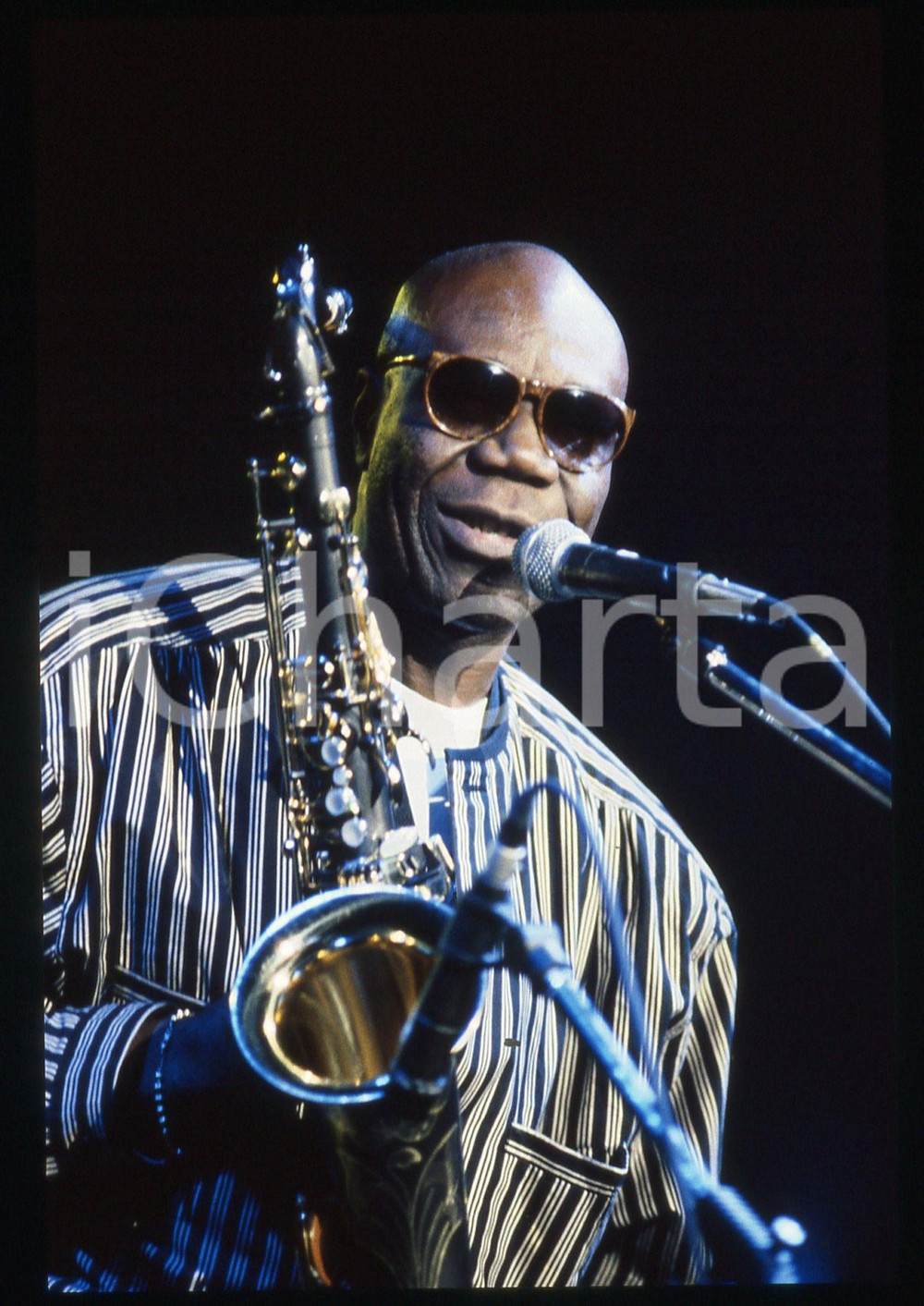 35mm vintage slide* 1990ca MUSICA Manu DIBANGO durante un concerto (2) Diapositiva d'epoca, in formato 35 mm. CONDIZIONI: GOODE' severamente vietata la riproduzione. Tutti i diritti sono riservati. ICharta mette in vendita, sul negozio eBay e in esclusiva sul sito "icharta" il proprio archivio composto da numerose diapositive e negativi fotografici d'epoca, tutti originali e autentici, che attraversano la storia del costume italiano tra gli la fine degli anni Sessanta e Novanta.Si tratta di uno sguardo inedito sull'attualit&agrave;, la politica, la vita quotidiana, il gossip e la cultura, che fotografa il cambiamento della nazione in quest'ultimo scorcio del XX secolo. Un'occasione unica per il mercato del collezionismo, che vede finalmente disponibile un archivio eccezionale per vastit&agrave;, tematiche e condizioni, in un settore (il negativo fotografico e la diapositiva) di assoluta novit&agrave; e dalle interessanti prospettive di investimento.  originale e autentica 1