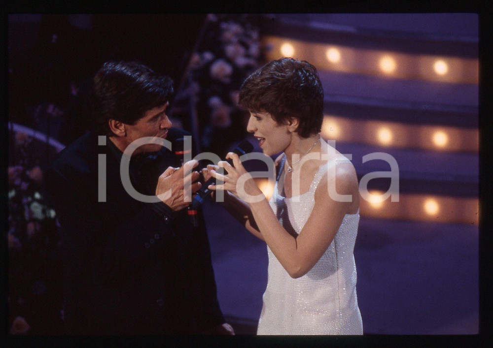 35mm vintage slide* 1995 SANREMO Gianni MORANDI e Barbara COLA all'Ariston (10) Diapositiva d'epoca, in formato 35 mm. CONDIZIONI: GOODE' severamente vietata la riproduzione. Tutti i diritti sono riservati.Nella diapositiva ICharta mette in vendita, sul negozio eBay e in esclusiva sul sito "icharta" il proprio archivio composto da numerose diapositive e negativi fotografici d'epoca, tutti originali e autentici, che attraversano la storia del costume italiano tra gli la fine degli anni Sessanta e Novanta.Si tratta di uno sguardo inedito sull'attualit&agrave;, la politica, la vita quotidiana, il gossip e la cultura, che fotografa il cambiamento della nazione in quest'ultimo scorcio del XX secolo. Un'occasione unica per il mercato del collezionismo, che vede finalmente disponibile un archivio eccezionale per vastit&agrave;, tematiche e condizioni, in un settore (il negativo fotografico e la diapositiva) di assoluta novit&agrave; e dalle interessanti prospettive di investimento.  originale e autentica 1