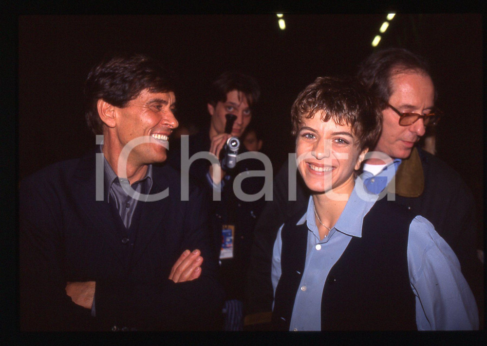 35mm vintage slide* 1995 SANREMO Gianni MORANDI e Barbara COLA Ritratto (3) La diapositiva &egrave; stata scattata in occasione del FestivalDiapositiva d'epoca, in formato 35 mm. CONDIZIONI: GOODE' severamente vietata la riproduzione. Tutti i diritti sono riservati.Nella diapositiva ICharta mette in vendita, sul negozio eBay e in esclusiva sul sito "icharta" il proprio archivio composto da numerose diapositive e negativi fotografici d'epoca, tutti originali e autentici, che attraversano la storia del costume italiano tra gli la fine degli anni Sessanta e Novanta.Si tratta di uno sguardo inedito sull'attualit&agrave;, la politica, la vita quotidiana, il gossip e la cultura, che fotografa il cambiamento della nazione in quest'ultimo scorcio del XX secolo. Un'occasione unica per il mercato del collezionismo, che vede finalmente disponibile un archivio eccezionale per vastit&agrave;, tematiche e condizioni, in un settore (il negativo fotografico e la diapositiva) di assoluta novit&agrave; e dalle interessanti prospettive di investimento.  originale e autentica 1