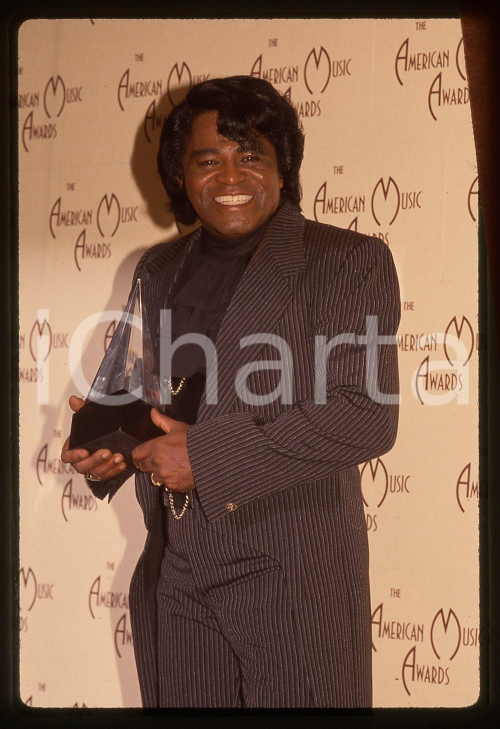 35mm vintage slide* 1992 LOS ANGELES James BROWN agli AMERICAN MUSIC AWARDS 4 Diapositiva d'epoca, in formato 35 mm. CONDIZIONI: GOODE' severamente vietata la riproduzione. Tutti i diritti sono riservati.Nella diapositiva ICharta mette in vendita, sul negozio eBay e in esclusiva sul sito "icharta" il proprio archivio composto da numerose diapositive e negativi fotografici d'epoca, tutti originali e autentici, che attraversano la storia del costume italiano tra gli la fine degli anni Sessanta e Novanta.Si tratta di uno sguardo inedito sull'attualit&agrave;, la politica, la vita quotidiana, il gossip e la cultura, che fotografa il cambiamento della nazione in quest'ultimo scorcio del XX secolo. Un'occasione unica per il mercato del collezionismo, che vede finalmente disponibile un archivio eccezionale per vastit&agrave;, tematiche e condizioni, in un settore (il negativo fotografico e la diapositiva) di assoluta novit&agrave; e dalle interessanti prospettive di investimento.  originale e autentica 1