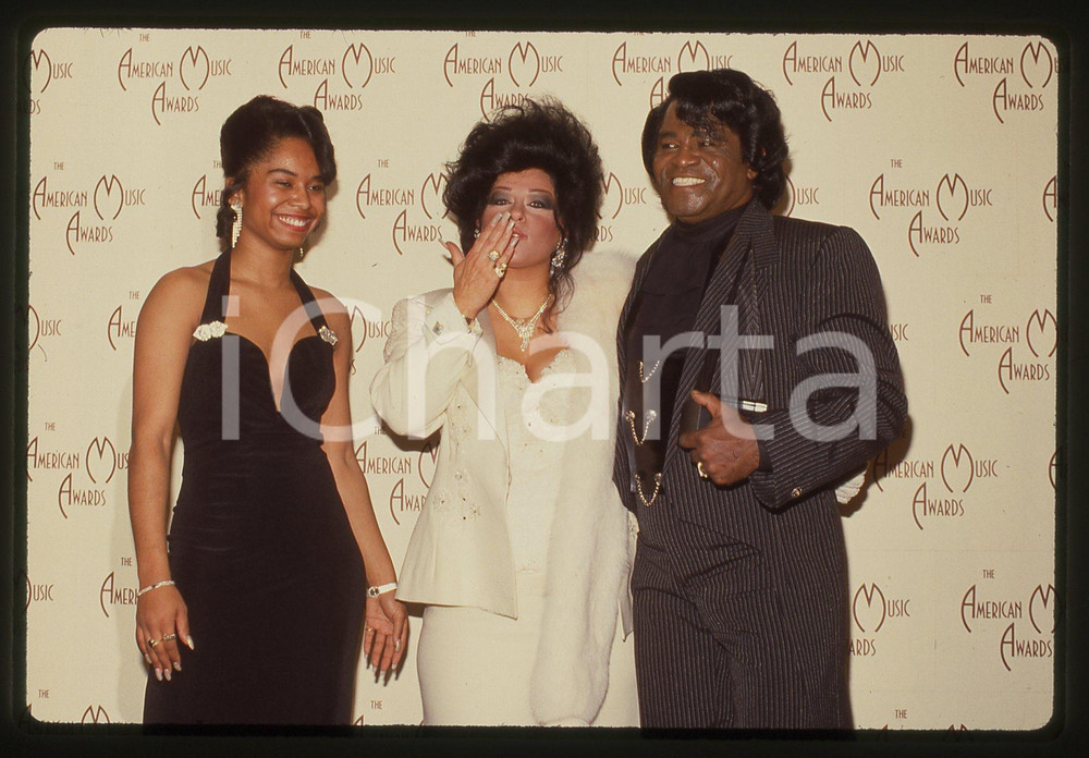 35mm vintage slide* 1992 LOS ANGELES James BROWN Adrienne RODRIGUEZ agli AMA Diapositiva d'epoca, in formato 35 mm. CONDIZIONI: GOODE' severamente vietata la riproduzione. Tutti i diritti sono riservati.Nella diapositiva ICharta mette in vendita, sul negozio eBay e in esclusiva sul sito "icharta" il proprio archivio composto da numerose diapositive e negativi fotografici d'epoca, tutti originali e autentici, che attraversano la storia del costume italiano tra gli la fine degli anni Sessanta e Novanta.Si tratta di uno sguardo inedito sull'attualit&agrave;, la politica, la vita quotidiana, il gossip e la cultura, che fotografa il cambiamento della nazione in quest'ultimo scorcio del XX secolo. Un'occasione unica per il mercato del collezionismo, che vede finalmente disponibile un archivio eccezionale per vastit&agrave;, tematiche e condizioni, in un settore (il negativo fotografico e la diapositiva) di assoluta novit&agrave; e dalle interessanti prospettive di investimento.  originale e autentica 1