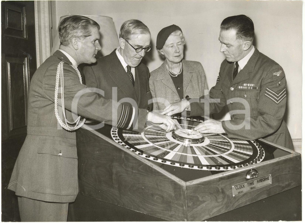 1958 LONDON - Frederick Gilbert JOHNS explains his JET CLOCK to Geoffrey TUTTLE