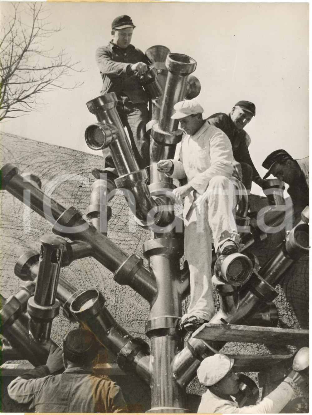 1954 MESSE MUNICH - Workers attach the branches of their pipe-line tree *Photo
