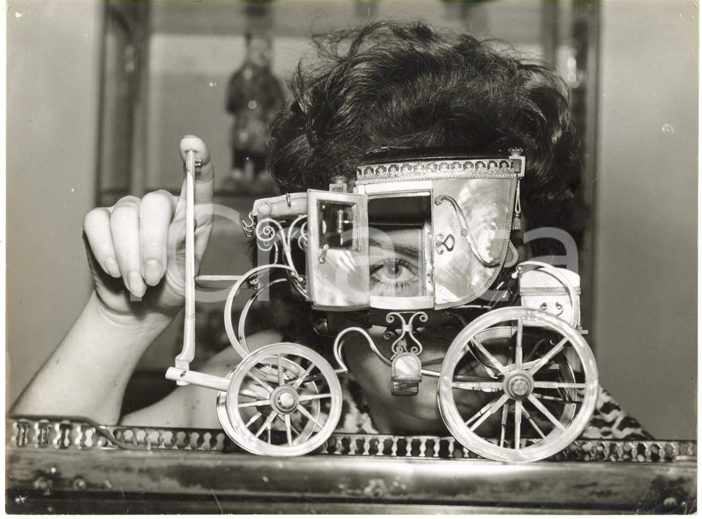 1959 LONDON Grosvenor House - Woman looks into a model of a travelling coach 