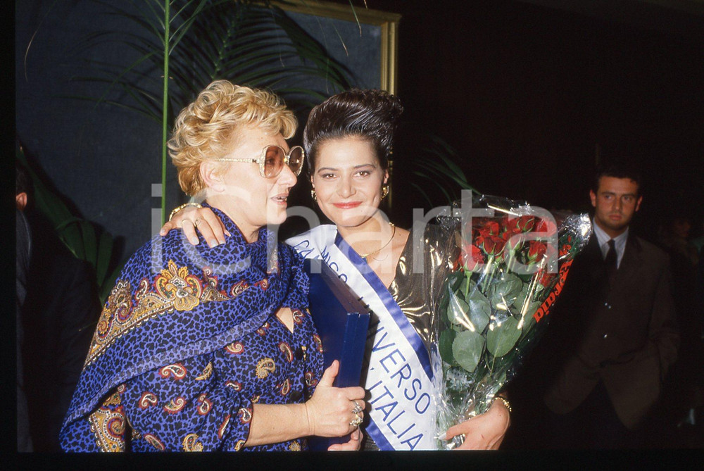 35mm vintage slide*1988 CAMPIONE D'ITALIA Simona VENTURA MISS UNIVERSO ITALIA 22 Diapositiva d'epoca, in formato 35 mm.Nella diapositiva insieme a Simona Ventura la mamma Anna Pagnoni. CONDIZIONI: GOODE' severamente vietata la riproduzione. Tutti i diritti sono riservati. ICharta mette in vendita, sul negozio eBay e in esclusiva sul sito "icharta" il proprio archivio composto da numerose diapositive e negativi fotografici d'epoca, tutti originali e autentici, che attraversano la storia del costume italiano tra gli la fine degli anni Sessanta e Novanta.Si tratta di uno sguardo inedito sull'attualit&agrave;, la politica, la vita quotidiana, il gossip e la cultura, che fotografa il cambiamento della nazione in quest'ultimo scorcio del XX secolo. Un'occasione unica per il mercato del collezionismo, che vede finalmente disponibile un archivio eccezionale per vastit&agrave;, tematiche e condizioni, in un settore (il negativo fotografico e la diapositiva) di assoluta novit&agrave; e dalle interessanti prospettive di investimento.  originale e autentica 1
