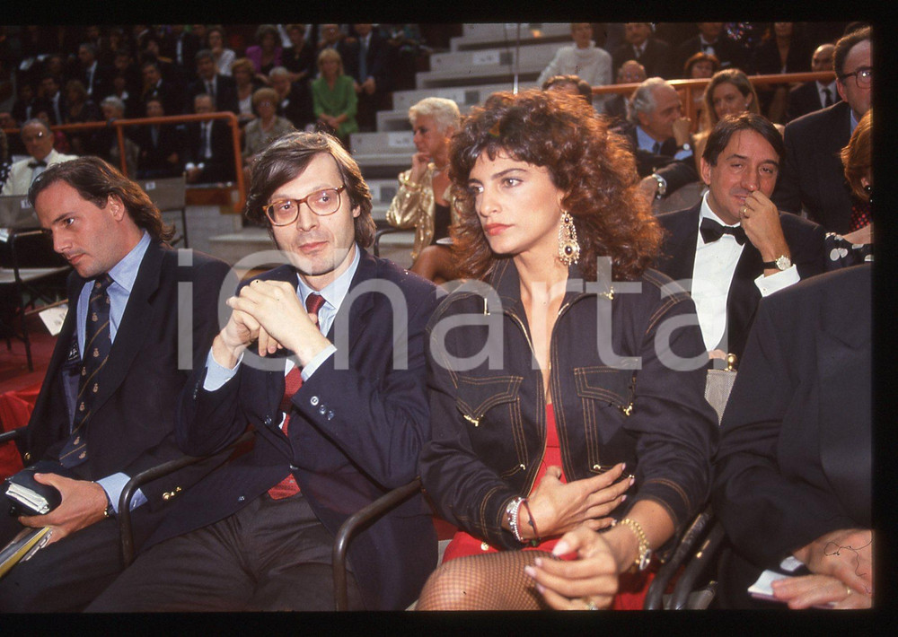 35mm vintage slide*1995ca  COSTUME Tiziana STELLA con Vittorio SGARBI  ritratto Diapositiva d'epoca, in formato 35 mm. CONDIZIONI: GOODE' severamente vietata la riproduzione. Tutti i diritti sono riservati. ICharta mette in vendita, sul negozio eBay e in esclusiva sul sito "icharta" il proprio archivio composto da numerose diapositive e negativi fotografici d'epoca, tutti originali e autentici, che attraversano la storia del costume italiano tra gli la fine degli anni Sessanta e Novanta.Si tratta di uno sguardo inedito sull'attualit&agrave;, la politica, la vita quotidiana, il gossip e la cultura, che fotografa il cambiamento della nazione in quest'ultimo scorcio del XX secolo. Un'occasione unica per il mercato del collezionismo, che vede finalmente disponibile un archivio eccezionale per vastit&agrave;, tematiche e condizioni, in un settore (il negativo fotografico e la diapositiva) di assoluta novit&agrave; e dalle interessanti prospettive di investimento.  originale e autentica 1