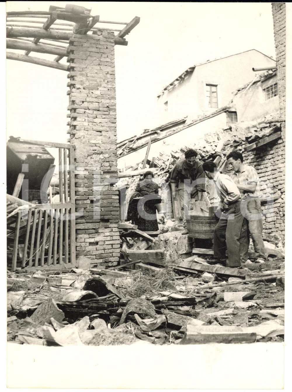 1957 ROBECCO PAVESE Contadini nella casa distrutta dal tornado *Foto 13x18 cm Fotografia d'epoca con didascalia coeva.  CONDIZIONI: FAIR (piccoli fori angolari; sovraimpressione circolare)FORMATO: 13x18 cm      originale e autentica 1