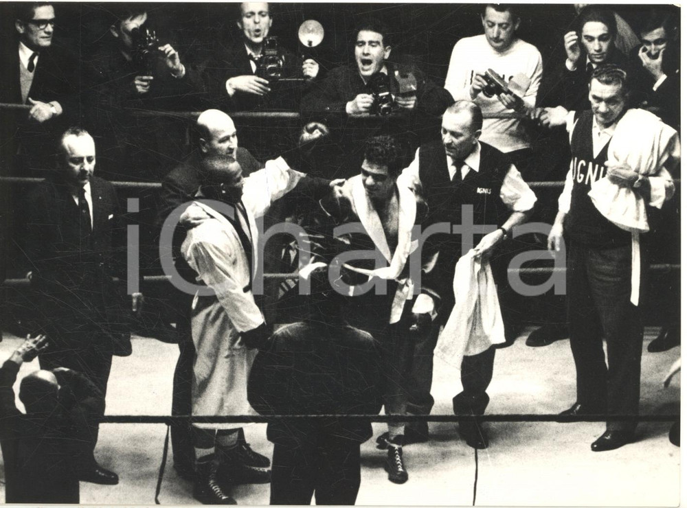 1962 MILANO BOXE Duilio LOI campione mondiale Welters jr contro Eddie PERKINS Fotografia d'epoca, con didascalia coeva al verso.  CONDIZIONI: POOR (piegatura centrale) FORMATO: 18x13 cm    originale e autentica 1