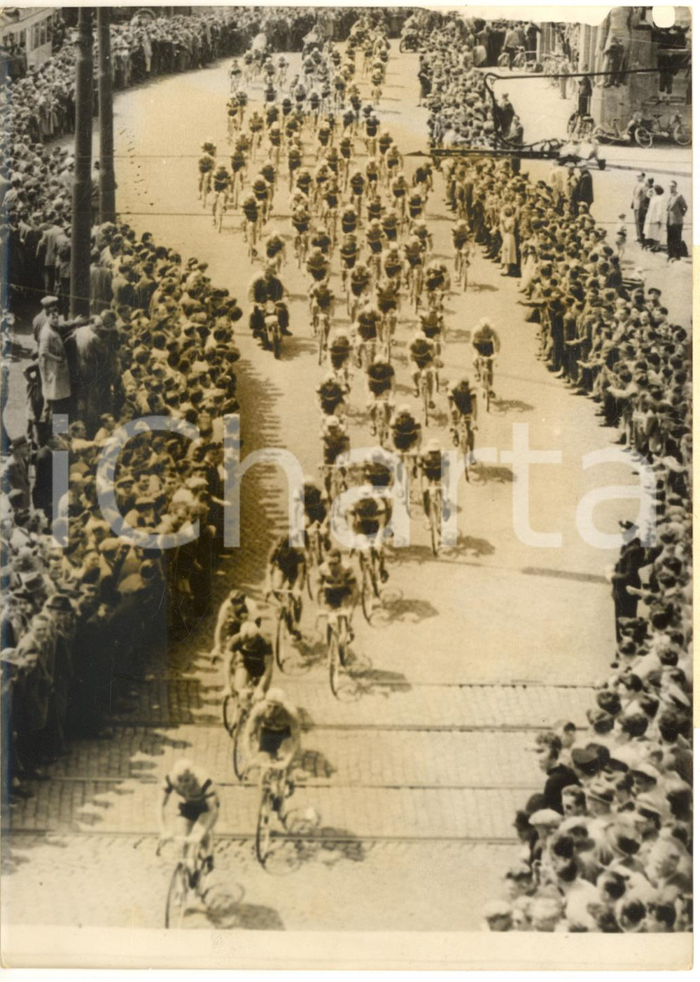 1957 CYCLISME TOUR DE FRANCE Le peloton traverse une ville au milieu de la foule