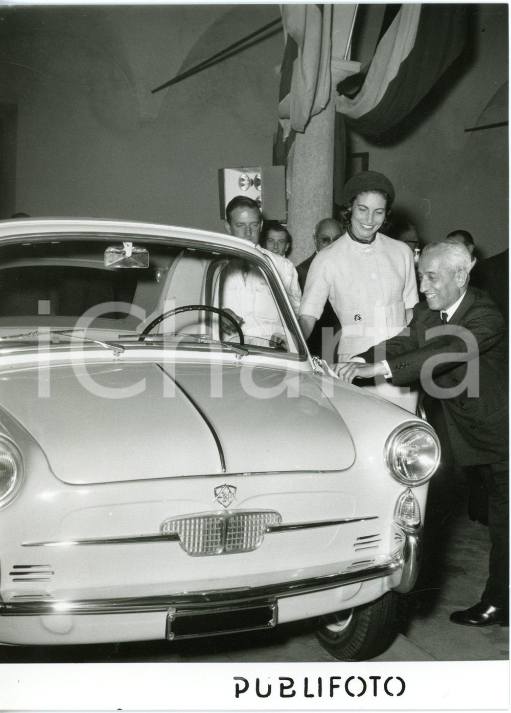 1957 MILANO - Vittorio VALLETTA alla presentazione nuova AUTOBIANCHI BIANCHINA  Fotografia d'epoca con didascalia dattiloscritta coeva.   CONDIZIONI: G (ma aloni in trasparenza, minimi difetti di stampa) FORMATO: 13x18 cm     originale e autentica 1