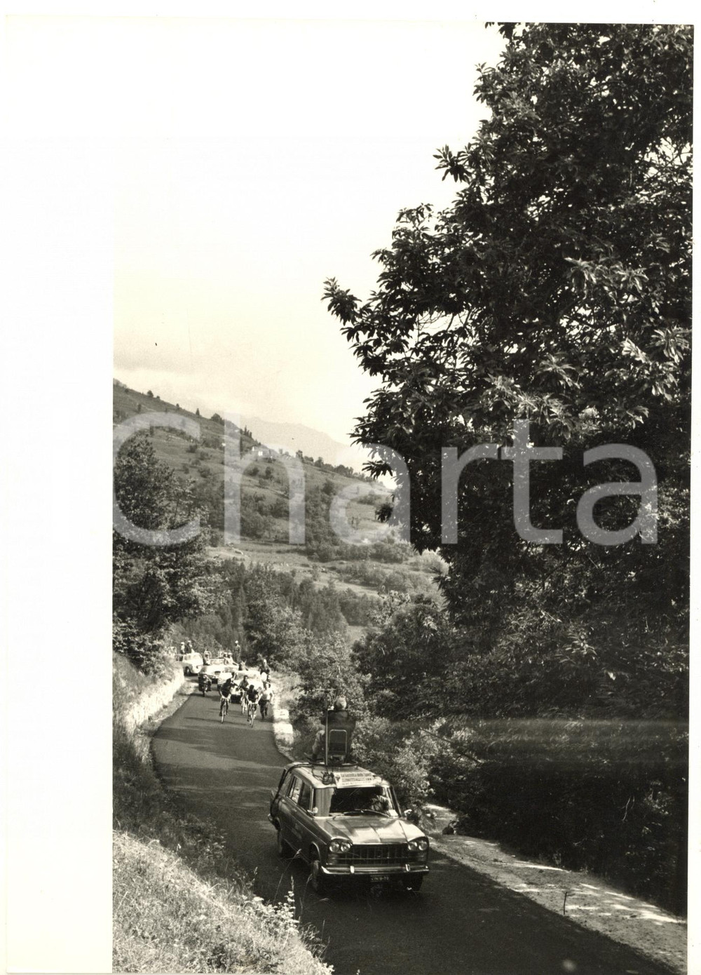 1960 ca CICLISMO GIRO D'ITALIA - Auto precede ciclisti in fuga sulle colline
