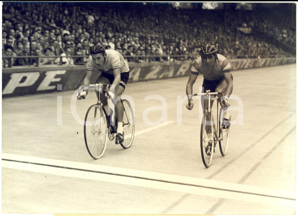 1957 PARIS Omnium des Vainqueurs - Jacques ANQUETIL Gastone NENCINI in gara  Fotografia d'epoca con didascalia coeva.  CONDIZIONI: FAIR (alone, difetti di stampa e sovraimpressione circolare) FORMATO: 18x13 cm     originale e autentica 1