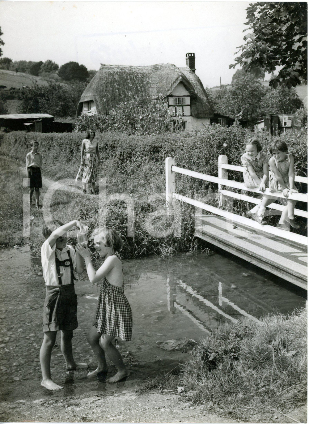 1955 PIDDLETRENTHIDE Children looking their jar of tiddlers from shallow stream