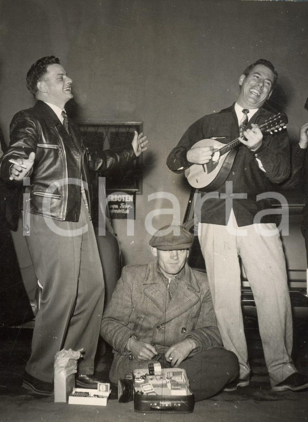 1953 MUNICH - UD lieutenants Jimmy BOARD and Eli ELIASEN sing to help a man