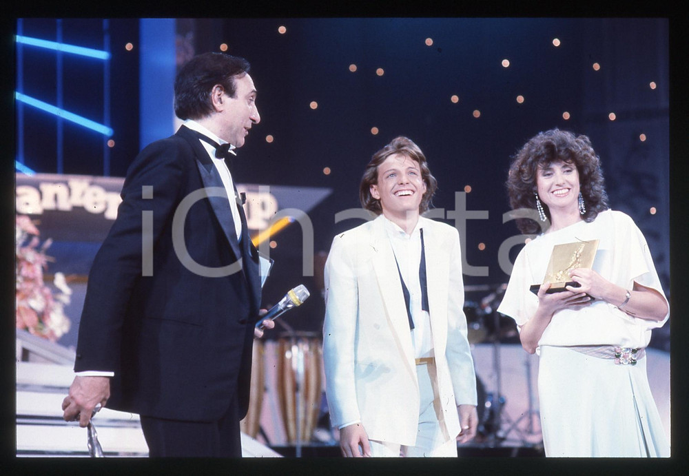 35mm vintage slide* 1985 SANREMO Luis MIGUEL Pippo BAUDO Gigliola CINQUETTI Fotografia realizzata alla serata finale del Festival.Diapositiva d'epoca, in formato 35 mm.   CONDIZIONI: GOODE' severamente vietata la riproduzione. Tutti i diritti sono riservati. ICharta mette in vendita, sul negozio eBay e in esclusiva sul sito "icharta" il proprio archivio composto da numerose diapositive e negativi fotografici d'epoca, tutti originali e autentici, che attraversano la storia del costume italiano tra gli la fine degli anni Sessanta e Novanta.Si tratta di uno sguardo inedito sull'attualit&agrave;, la politica, la vita quotidiana, il gossip e la cultura, che fotografa il cambiamento della nazione in quest'ultimo scorcio del XX secolo. Un'occasione unica per il mercato del collezionismo, che vede finalmente disponibile un archivio eccezionale per vastit&agrave;, tematiche e condizioni, in un settore (il negativo fotografico e la diapositiva) di assoluta novit&agrave; e dalle interessanti prospettive di investimento.  originale e autentica 1