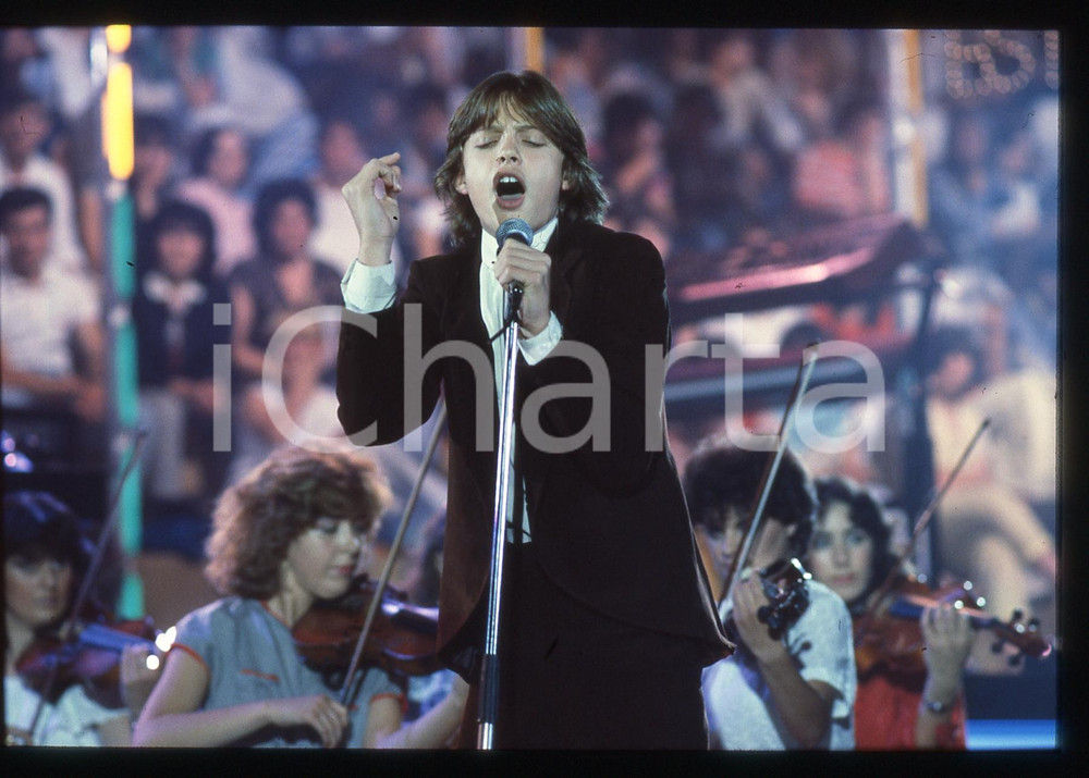 35mm vintage slide* 1984 SAINT VINCENT ESTATE Luis MIGUEL durante esibizione (1) Nel concorso canta Non mi devi trattar cos&igrave;.Diapositiva d'epoca, in formato 35 mm.   CONDIZIONI: GOODE' severamente vietata la riproduzione. Tutti i diritti sono riservati. ICharta mette in vendita, sul negozio eBay e in esclusiva sul sito "icharta" il proprio archivio composto da numerose diapositive e negativi fotografici d'epoca, tutti originali e autentici, che attraversano la storia del costume italiano tra gli la fine degli anni Sessanta e Novanta.Si tratta di uno sguardo inedito sull'attualit&agrave;, la politica, la vita quotidiana, il gossip e la cultura, che fotografa il cambiamento della nazione in quest'ultimo scorcio del XX secolo. Un'occasione unica per il mercato del collezionismo, che vede finalmente disponibile un archivio eccezionale per vastit&agrave;, tematiche e condizioni, in un settore (il negativo fotografico e la diapositiva) di assoluta novit&agrave; e dalle interessanti prospettive di investimento.  originale e autentica 1