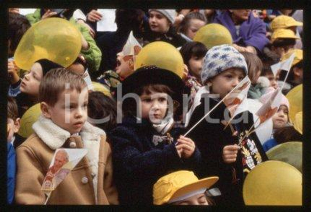35mm vintage slide* 1996, VAL D'ELSA AND SIENA - GIOVANNI PAOLO II, children  Diapositiva d'epoca, in formato 35 mm.CONDIZIONI: GOODE' severamente vietata la riproduzione. Tutti i diritti sono riservati.Nella diapositiva ICharta mette in vendita, sul negozio eBay e in esclusiva sul sito "icharta" il proprio archivio composto da numerose diapositive e negativi fotografici d'epoca, tutti originali e autentici, che attraversano la storia del costume italiano tra gli la fine degli anni Sessanta e Novanta.Si tratta di uno sguardo inedito sull'attualit&agrave;, la politica, la vita quotidiana, il gossip e la cultura, che fotografa il cambiamento della nazione in quest'ultimo scorcio del XX secolo. Un'occasione unica per il mercato del collezionismo, che vede finalmente disponibile un archivio eccezionale per vastit&agrave;, tematiche e condizioni, in un settore (il negativo fotografico e la diapositiva) di assoluta novit&agrave; e dalle interessanti prospettive di investimento. GOOD/buono   originale e autentica 1