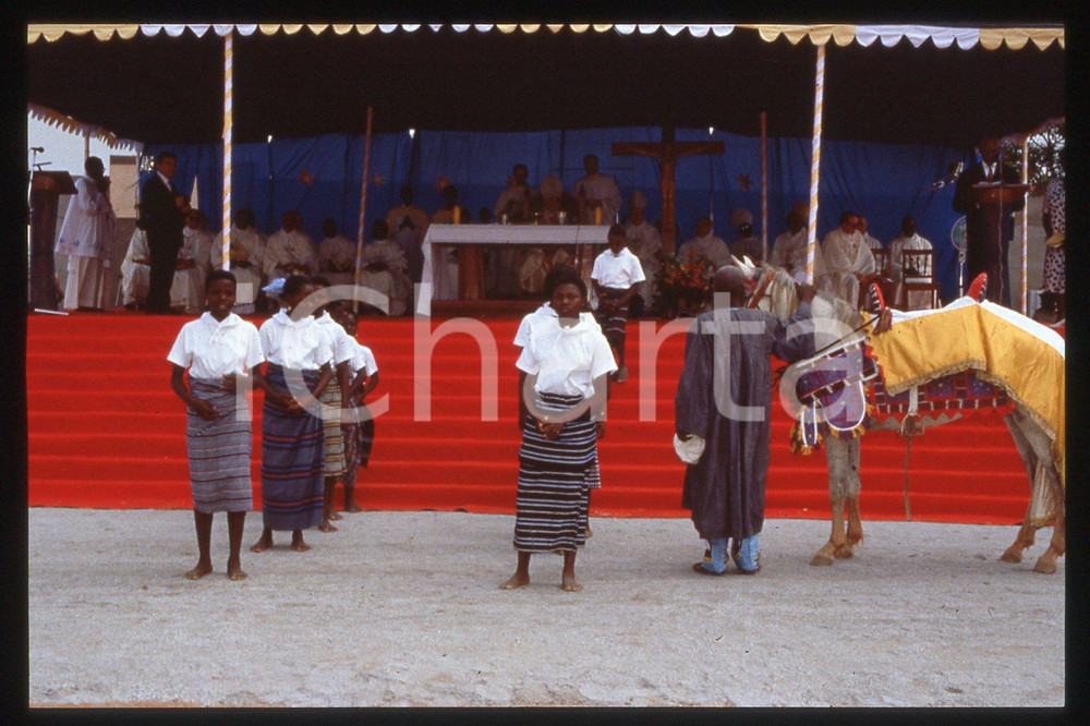 35mm vintage slide* 1993 BENIN Stadium PARAKAU Papa GIOVANNI PAOLO II (2)  Diapositiva d'epoca, in formato 35 mm.CONDIZIONI: GOODE' severamente vietata la riproduzione. Tutti i diritti sono riservati.Nella diapositiva ICharta mette in vendita, sul negozio eBay e in esclusiva sul sito "icharta" il proprio archivio composto da numerose diapositive e negativi fotografici d'epoca, tutti originali e autentici, che attraversano la storia del costume italiano tra gli la fine degli anni Sessanta e Novanta.Si tratta di uno sguardo inedito sull'attualit&agrave;, la politica, la vita quotidiana, il gossip e la cultura, che fotografa il cambiamento della nazione in quest'ultimo scorcio del XX secolo. Un'occasione unica per il mercato del collezionismo, che vede finalmente disponibile un archivio eccezionale per vastit&agrave;, tematiche e condizioni, in un settore (il negativo fotografico e la diapositiva) di assoluta novit&agrave; e dalle interessanti prospettive di investimento.  CONDIZIONI:FAIR/discreto originale e autentica 1