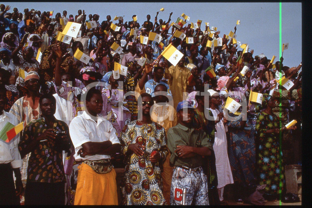 35mm vintage slide* 1993 BENIN Stadium PARAKAU People for GIOVANNI PAOLO II (2)  Diapositiva d'epoca, in formato 35 mm.CONDIZIONI: GOODE' severamente vietata la riproduzione. Tutti i diritti sono riservati.Nella diapositiva ICharta mette in vendita, sul negozio eBay e in esclusiva sul sito "icharta" il proprio archivio composto da numerose diapositive e negativi fotografici d'epoca, tutti originali e autentici, che attraversano la storia del costume italiano tra gli la fine degli anni Sessanta e Novanta.Si tratta di uno sguardo inedito sull'attualit&agrave;, la politica, la vita quotidiana, il gossip e la cultura, che fotografa il cambiamento della nazione in quest'ultimo scorcio del XX secolo. Un'occasione unica per il mercato del collezionismo, che vede finalmente disponibile un archivio eccezionale per vastit&agrave;, tematiche e condizioni, in un settore (il negativo fotografico e la diapositiva) di assoluta novit&agrave; e dalle interessanti prospettive di investimento.  FAIR/discreto   originale e autentica 1