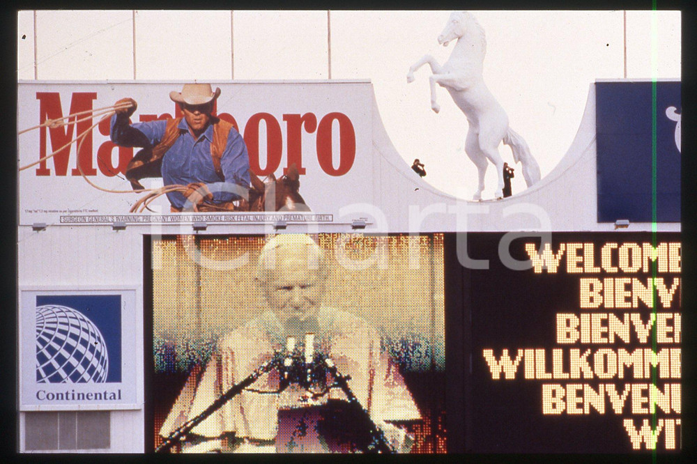 35mm vintage slide* 1993 DENVER STADIUM Giovanni Paolo II and MARLBORO  Diapositiva d'epoca, in formato 35 mm.CONDIZIONI: GOODE' severamente vietata la riproduzione. Tutti i diritti sono riservati.Nella diapositiva ICharta mette in vendita, sul negozio eBay e in esclusiva sul sito "icharta" il proprio archivio composto da numerose diapositive e negativi fotografici d'epoca, tutti originali e autentici, che attraversano la storia del costume italiano tra gli la fine degli anni Sessanta e Novanta.Si tratta di uno sguardo inedito sull'attualit&agrave;, la politica, la vita quotidiana, il gossip e la cultura, che fotografa il cambiamento della nazione in quest'ultimo scorcio del XX secolo. Un'occasione unica per il mercato del collezionismo, che vede finalmente disponibile un archivio eccezionale per vastit&agrave;, tematiche e condizioni, in un settore (il negativo fotografico e la diapositiva) di assoluta novit&agrave; e dalle interessanti prospettive di investimento.  FAIR/discreto   originale e autentica 1