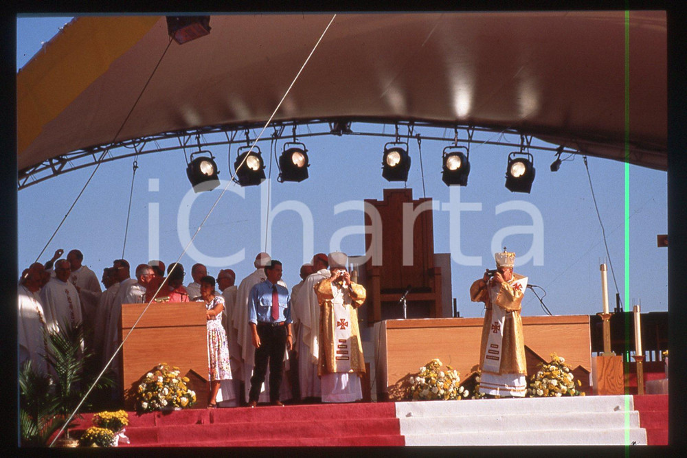 35mm vintage slide* 1993, Denver, Giovanni Paolo II, mass at Cherry Creek park  Diapositiva d'epoca, in formato 35 mm.CONDIZIONI: GOODE' severamente vietata la riproduzione. Tutti i diritti sono riservati.Nella diapositiva ICharta mette in vendita, sul negozio eBay e in esclusiva sul sito "icharta" il proprio archivio composto da numerose diapositive e negativi fotografici d'epoca, tutti originali e autentici, che attraversano la storia del costume italiano tra gli la fine degli anni Sessanta e Novanta.Si tratta di uno sguardo inedito sull'attualit&agrave;, la politica, la vita quotidiana, il gossip e la cultura, che fotografa il cambiamento della nazione in quest'ultimo scorcio del XX secolo. Un'occasione unica per il mercato del collezionismo, che vede finalmente disponibile un archivio eccezionale per vastit&agrave;, tematiche e condizioni, in un settore (il negativo fotografico e la diapositiva) di assoluta novit&agrave; e dalle interessanti prospettive di investimento.  FAIR/discreto   originale e autentica 1