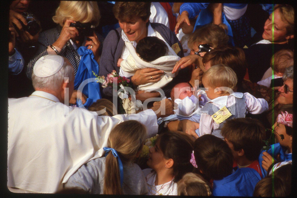 35mm vintage slide* 1986 France Giovanni Paolo II with children  Diapositiva d'epoca, in formato 35 mm.CONDIZIONI: GOODE' severamente vietata la riproduzione. Tutti i diritti sono riservati.Nella diapositiva ICharta mette in vendita, sul negozio eBay e in esclusiva sul sito "icharta" il proprio archivio composto da numerose diapositive e negativi fotografici d'epoca, tutti originali e autentici, che attraversano la storia del costume italiano tra gli la fine degli anni Sessanta e Novanta.Si tratta di uno sguardo inedito sull'attualit&agrave;, la politica, la vita quotidiana, il gossip e la cultura, che fotografa il cambiamento della nazione in quest'ultimo scorcio del XX secolo. Un'occasione unica per il mercato del collezionismo, che vede finalmente disponibile un archivio eccezionale per vastit&agrave;, tematiche e condizioni, in un settore (il negativo fotografico e la diapositiva) di assoluta novit&agrave; e dalle interessanti prospettive di investimento.  FAIR/discreto   originale e autentica 1