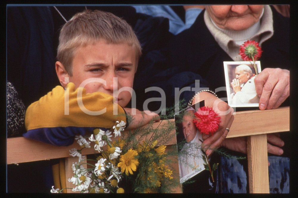 35mm vintage slide* 1993 Vilnius, Giovanni Paolo II, people vaiting for POPE  Diapositiva d'epoca, in formato 35 mm.E' severamente vietata la riproduzione. Tutti i diritti sono riservati. ICharta mette in vendita, sul negozio eBay e in esclusiva sul sito "icharta" il proprio archivio composto da numerose diapositive e negativi fotografici d'epoca, tutti originali e autentici, che attraversano la storia del costume tra la fine degli anni Sessanta e Novanta.Si tratta di uno sguardo inedito sull'attualità, la politica, la vita quotidiana, il gossip e la cultura, che fotografa il cambiamento della nazione in quest'ultimo scorcio del XX secolo. Un'occasione unica per il mercato del collezionismo, che vede finalmente disponibile un archivio eccezionale per vastità, tematiche e condizioni, in un settore (il negativo fotografico e la diapositiva) di assoluta novità e dalle interessanti prospettive di investimento.   FAIR/discreto   originale e autentica 1