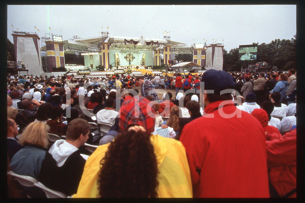 35mm vintage slide* 1995 NEW YORK Central Park - Pope's Mass - People  Diapositiva d'epoca, in formato 35 mm.CONDIZIONI: GOODE' severamente vietata la riproduzione. Tutti i diritti sono riservati.Nella diapositiva ICharta mette in vendita, sul negozio eBay e in esclusiva sul sito "icharta" il proprio archivio composto da numerose diapositive e negativi fotografici d'epoca, tutti originali e autentici, che attraversano la storia del costume italiano tra gli la fine degli anni Sessanta e Novanta.Si tratta di uno sguardo inedito sull'attualit&agrave;, la politica, la vita quotidiana, il gossip e la cultura, che fotografa il cambiamento della nazione in quest'ultimo scorcio del XX secolo. Un'occasione unica per il mercato del collezionismo, che vede finalmente disponibile un archivio eccezionale per vastit&agrave;, tematiche e condizioni, in un settore (il negativo fotografico e la diapositiva) di assoluta novit&agrave; e dalle interessanti prospettive di investimento.  FAIR/discreto   originale e autentica 1