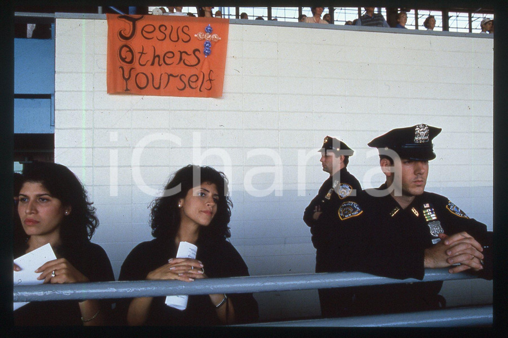 35mm vintage slide* 1995 BROOKLYN Aqueduct Racetrack - People waiting for Pope  Diapositiva d'epoca, in formato 35 mm.CONDIZIONI: GOODE' severamente vietata la riproduzione. Tutti i diritti sono riservati.Nella diapositiva ICharta mette in vendita, sul negozio eBay e in esclusiva sul sito "icharta" il proprio archivio composto da numerose diapositive e negativi fotografici d'epoca, tutti originali e autentici, che attraversano la storia del costume italiano tra gli la fine degli anni Sessanta e Novanta.Si tratta di uno sguardo inedito sull'attualit&agrave;, la politica, la vita quotidiana, il gossip e la cultura, che fotografa il cambiamento della nazione in quest'ultimo scorcio del XX secolo. Un'occasione unica per il mercato del collezionismo, che vede finalmente disponibile un archivio eccezionale per vastit&agrave;, tematiche e condizioni, in un settore (il negativo fotografico e la diapositiva) di assoluta novit&agrave; e dalle interessanti prospettive di investimento.  FAIR/discreto   originale e autentica 1
