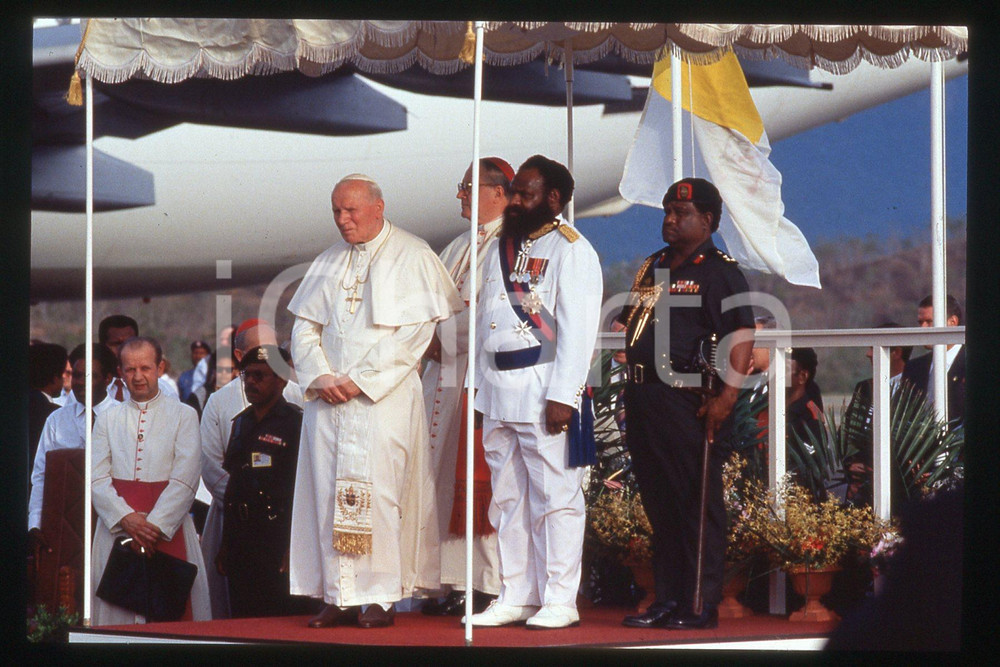 35mm vintage slide* 1995, Papuasia, flag, Giovanni Paolo II  Diapositiva d'epoca, in formato 35 mm.CONDIZIONI: GOODE' severamente vietata la riproduzione. Tutti i diritti sono riservati.Nella diapositiva ICharta mette in vendita, sul negozio eBay e in esclusiva sul sito "icharta" il proprio archivio composto da numerose diapositive e negativi fotografici d'epoca, tutti originali e autentici, che attraversano la storia del costume italiano tra gli la fine degli anni Sessanta e Novanta.Si tratta di uno sguardo inedito sull'attualit&agrave;, la politica, la vita quotidiana, il gossip e la cultura, che fotografa il cambiamento della nazione in quest'ultimo scorcio del XX secolo. Un'occasione unica per il mercato del collezionismo, che vede finalmente disponibile un archivio eccezionale per vastit&agrave;, tematiche e condizioni, in un settore (il negativo fotografico e la diapositiva) di assoluta novit&agrave; e dalle interessanti prospettive di investimento.  FAIR/discreto   originale e autentica 1