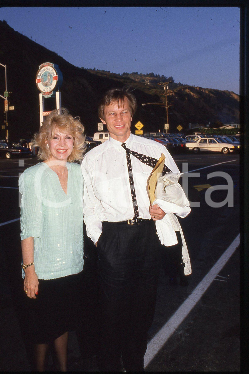 35mm vintage slide* 1986, California, an actor Michael York and his wife  Diapositiva d'epoca, in formato 35 mm.CONDIZIONI: GOODE' severamente vietata la riproduzione. Tutti i diritti sono riservati.Nella diapositiva ICharta mette in vendita, sul negozio eBay e in esclusiva sul sito "icharta" il proprio archivio composto da numerose diapositive e negativi fotografici d'epoca, tutti originali e autentici, che attraversano la storia del costume italiano tra gli la fine degli anni Sessanta e Novanta.Si tratta di uno sguardo inedito sull'attualit&agrave;, la politica, la vita quotidiana, il gossip e la cultura, che fotografa il cambiamento della nazione in quest'ultimo scorcio del XX secolo. Un'occasione unica per il mercato del collezionismo, che vede finalmente disponibile un archivio eccezionale per vastit&agrave;, tematiche e condizioni, in un settore (il negativo fotografico e la diapositiva) di assoluta novit&agrave; e dalle interessanti prospettive di investimento.  FAIR/discreto   originale e autentica 1