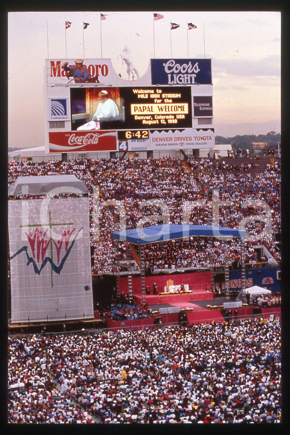 35mm vintage slide* 1993 DENVER STADIUM Giovanni Paolo II - Papal welcome  Diapositiva d'epoca, in formato 35 mm.CONDIZIONI: GOODE' severamente vietata la riproduzione. Tutti i diritti sono riservati.Nella diapositiva ICharta mette in vendita, sul negozio eBay e in esclusiva sul sito "icharta" il proprio archivio composto da numerose diapositive e negativi fotografici d'epoca, tutti originali e autentici, che attraversano la storia del costume italiano tra gli la fine degli anni Sessanta e Novanta.Si tratta di uno sguardo inedito sull'attualit&agrave;, la politica, la vita quotidiana, il gossip e la cultura, che fotografa il cambiamento della nazione in quest'ultimo scorcio del XX secolo. Un'occasione unica per il mercato del collezionismo, che vede finalmente disponibile un archivio eccezionale per vastit&agrave;, tematiche e condizioni, in un settore (il negativo fotografico e la diapositiva) di assoluta novit&agrave; e dalle interessanti prospettive di investimento.  FAIR/discreto   originale e autentica 1