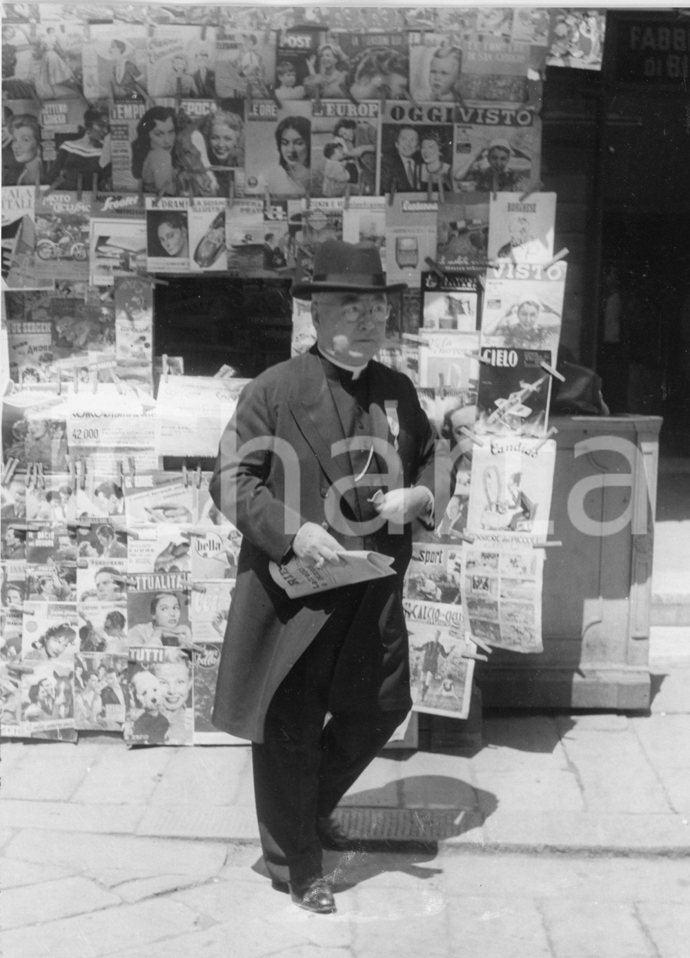 1954 GENOVA Il cardinale Francis Joseph SPELLMAN in edicola (1) Foto 18x24 cm 1954Fotografia vintage rara d'epoca.Timbro archivio Publifoto Genova al verso.FORMATO: 18x24 cm CONDIZIONI: GICHARTA mette in vendita le stampe vintage della collezione Publifoto Genova, per la maggior parte inedita o in tiratura di pochi esemplari. Si tratta di un'ottima opportunit&agrave; di investimento per i collezionisti di fotografie d'epoca.    originale e autentica 1